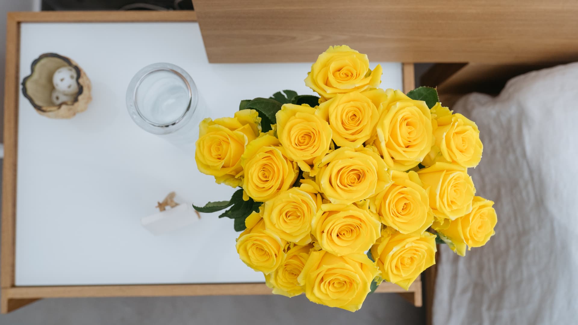 Yellow roses on a bedside table seen from above